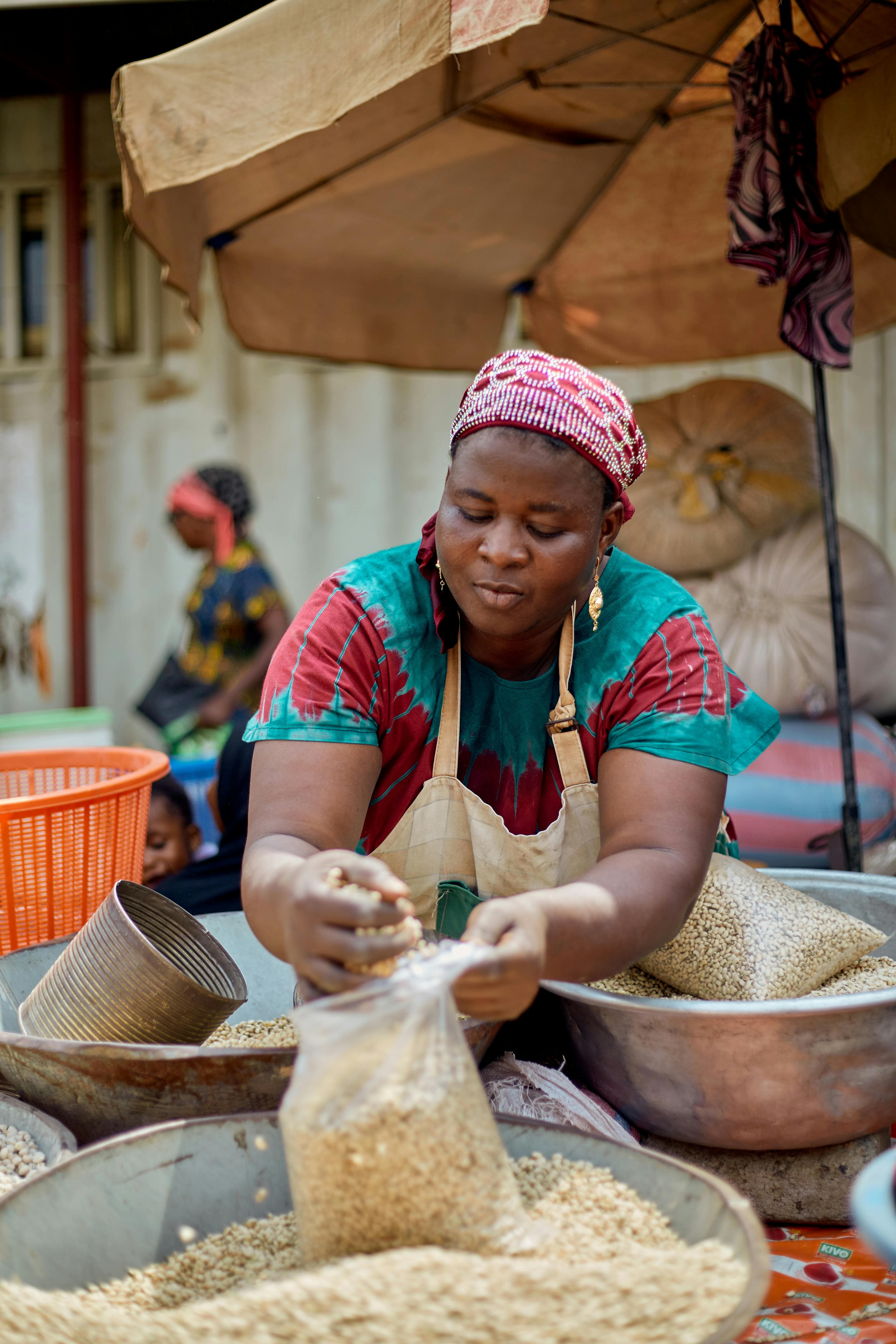 A market trader at her fruit stall holding ripe soursop